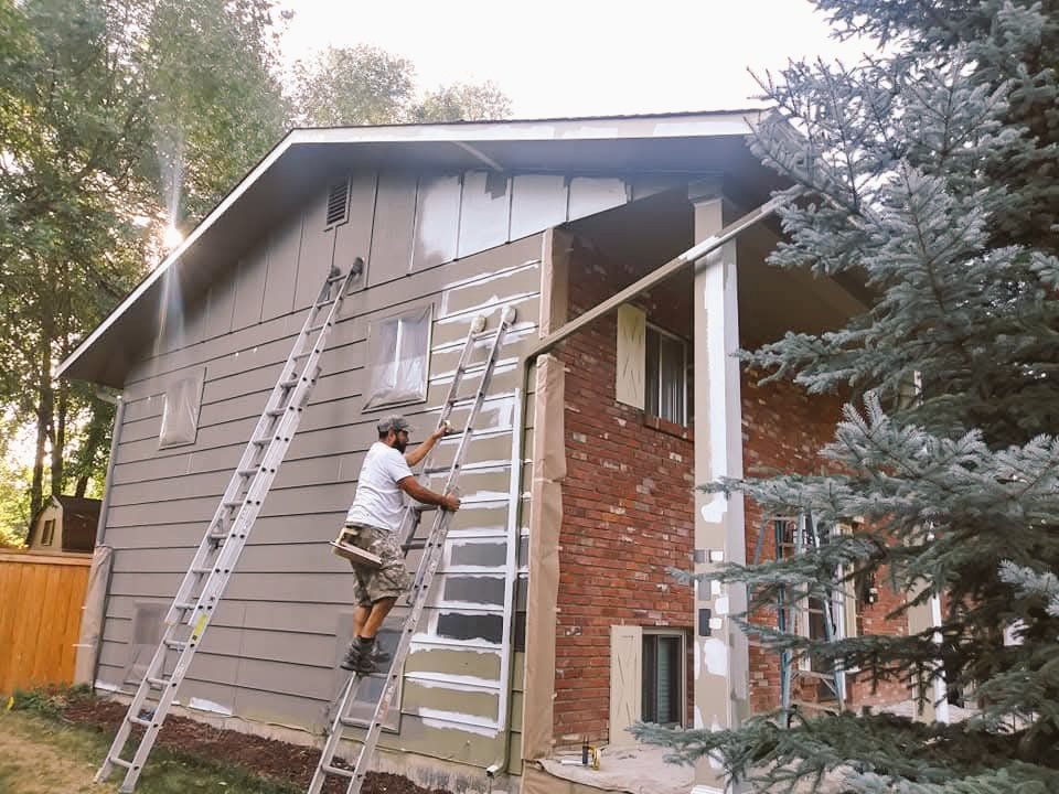 ColorTrends painter prepping and repainting exterior siding on the job